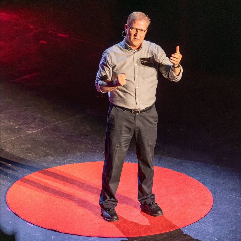 Cameron Miner delivering his TEDx Portsmouth talk on stage
